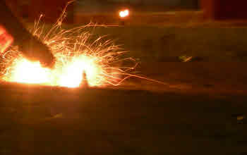 Lighting a firework on the ground.
