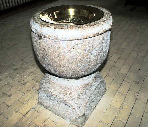 A stone font for baptisms. Baptism meaning - Problematic in practice